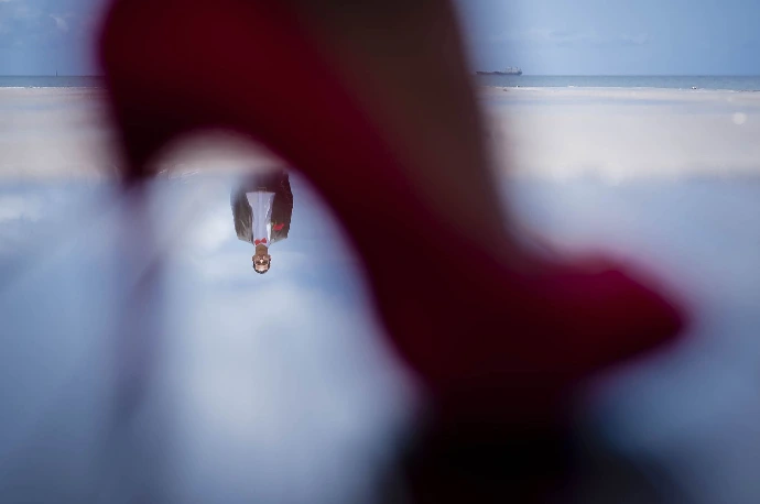 Reflet du marié dans une flaque sous la chaussure de la mariée