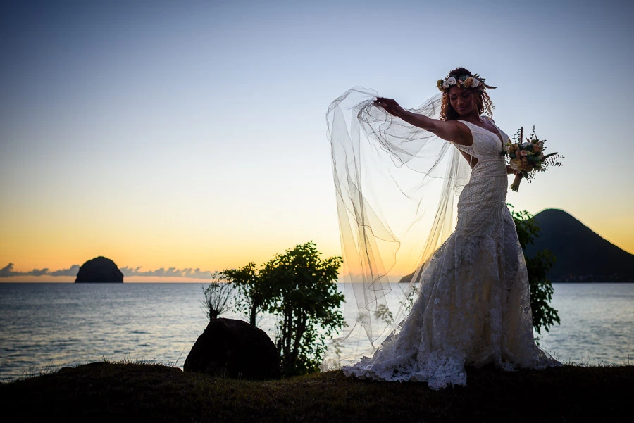 La mariée prend la pause au coucher du soleil devant le Rocher du Diamant
